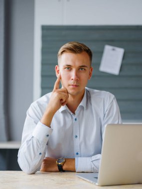 Bir dizüstü bilgisayarda office arka plan ile iş yapan ciddi erkek. Modern iş kavramı. Kopya alanı.