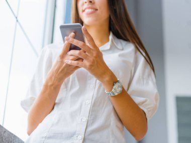 Yakın çekim öğrenci kız ile bir cep telefonu arka plan bulanık. Internet bağlantı kavramı.