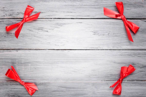 Cuatro arcos rojos en una mesa de madera gris . — Foto de Stock