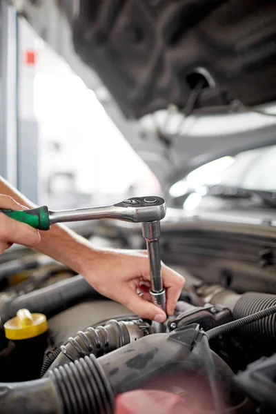 De mechanica handen op de achtergrond van de geopende motorkap reparaties de details — Stockfoto