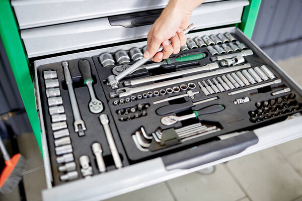 Hand on the background of a box with tools