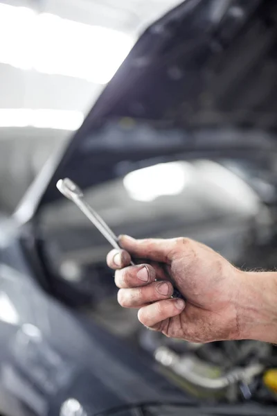 De mechanica handen op de achtergrond van de geopende motorkap reparaties de details — Stockfoto