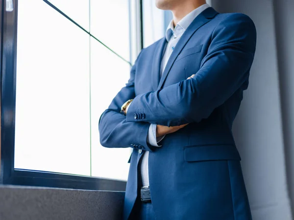 Un hombre de negocios de cerca con las manos cruzadas sobre un fondo borroso. Concepto de confianza . —  Fotos de Stock