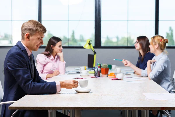 Een groep van kantoorpersoneel zitten aan de balie — Stockfoto