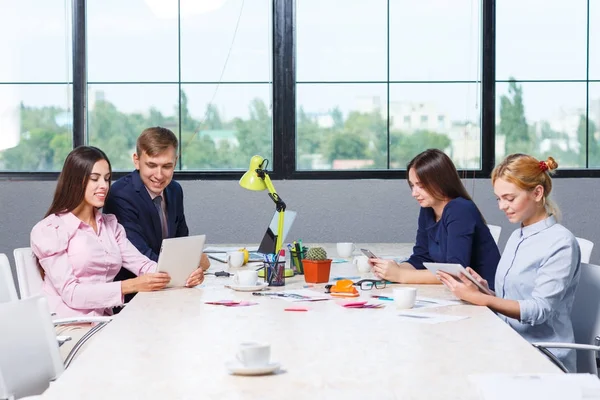 Een groep van kantoorpersoneel zitten aan de balie — Stockfoto