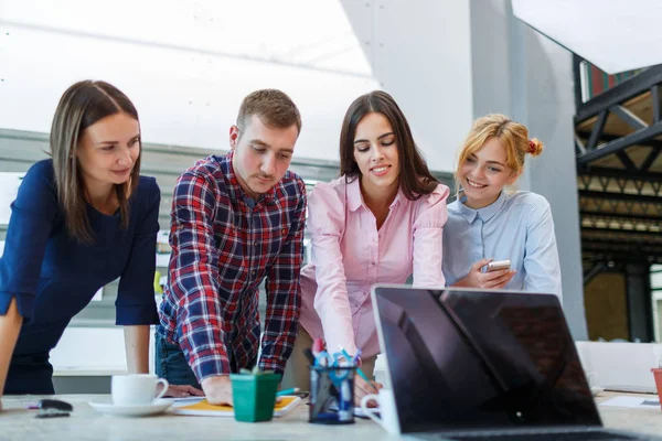 Laptop from the first person on the background of a group of office workers