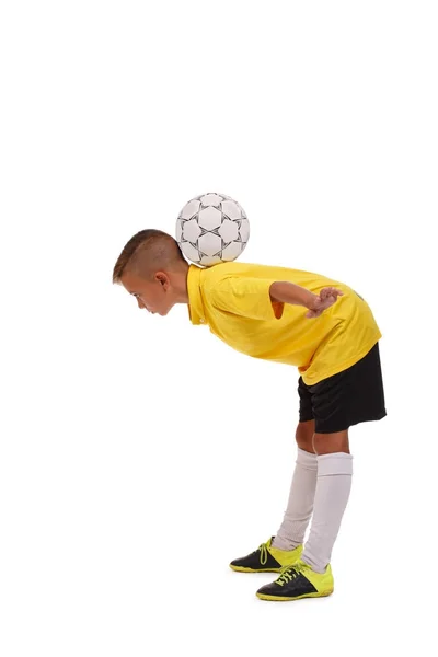 Çocuk bir top ile eğleniyor. Beyaz bir arka plan üzerinde izole genç futbol oyuncusu. Spor ekipmanları kavramı. — Stok fotoğraf