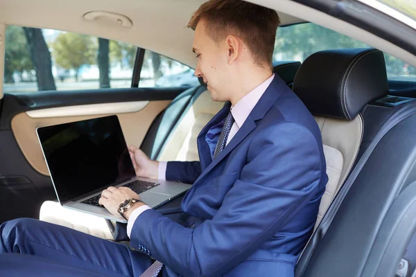 İşadamı dizüstü bilgisayarda çalışan araba