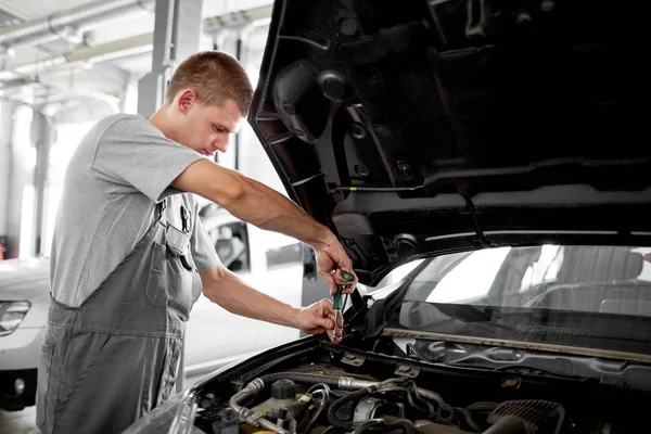 Szerelő javítás az autó, a motorháztető alatt közelről — Stock Fotó