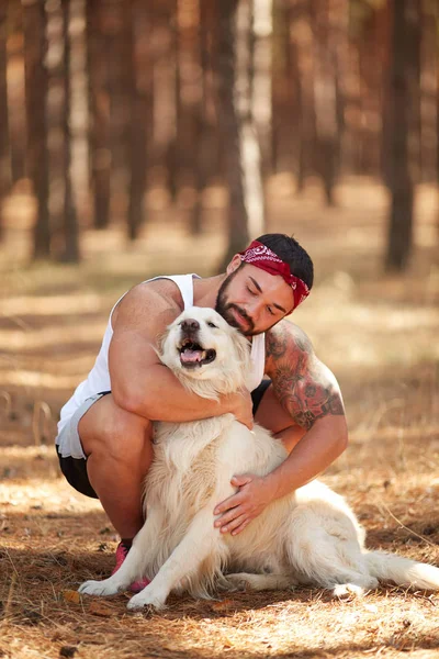 Ormanda açık yürüyen labrador köpek ile güçlü esmer adam.