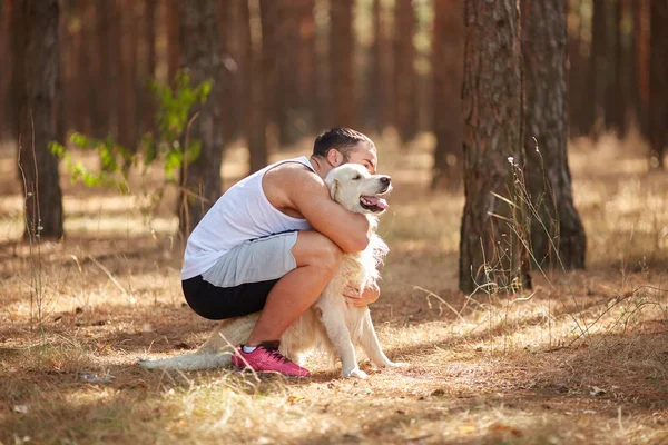 Forte brune homme avec labrador chien marche en forêt en plein air . — Photo