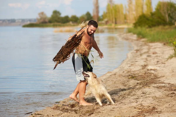 Ένας άντρας παίζει με ένα σκυλί στο νερό — Φωτογραφία Αρχείου