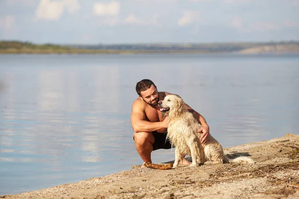 Bir adam seviyor ve onun köpek su üzerinde oynadıktan sonra övüyor