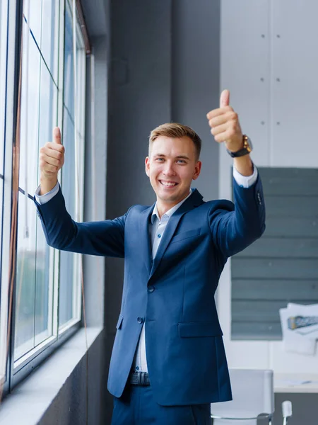 Un hombre de negocios sonriente animando el fondo de la oficina. Feliz oficinista. Concepto de éxito empresarial . —  Fotos de Stock