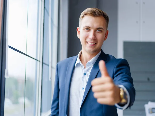 Empresario exitoso dando pulgares hacia arriba en el fondo de la oficina. Concepto de aprobación. Copiar espacio . —  Fotos de Stock