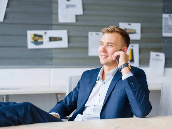 Feliz hombre de negocios guapo hablando por teléfono en el fondo de la oficina. Concepto de innovación . —  Fotos de Stock