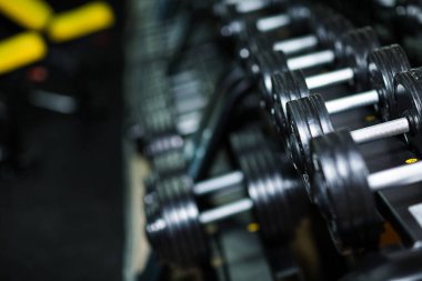 Ağır ekipman kullanılan ağırlık spor rutin, egzersiz programı, kilo karanlık bir arka plan bulanık büyütme güç ve kas büyüklük için eğitim.
