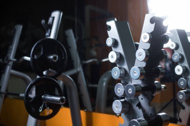 Barbell bir spor salonu ile bir stand. Halter tutucu üzerinde arka plan bulanık. Spor malzemeleri. Fitness, egzersiz, eğitim.