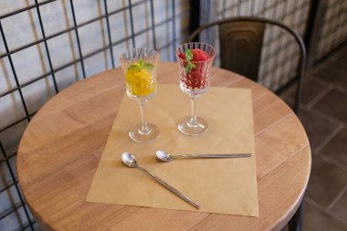 Dekoratif nane yaprakları yaz tatlılar. İki parlak berry dondurma kristal bardaklarda bölümünü fotoğrafı yakın çekim. 