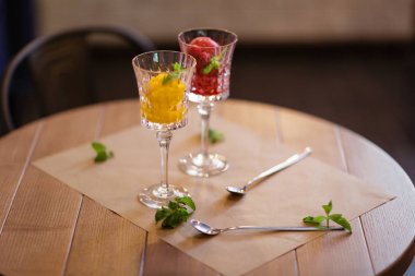 Dekoratif nane yaprakları yaz tatlılar. İki parlak berry dondurma kristal bardaklarda bölümünü fotoğrafı yakın çekim. 