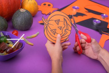 Hayalet, pumpkins, örümcekler ve dışarı-in kağıt kesme yarasalar ile bulut Çerçeve. Mor arka plan.