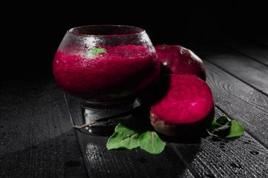 Yakın çekim yenileme ile geniş bir cam siyah bir arka plan üzerinde sebze güler yüzlü harmanlanmış. Şeker beetroots kesmek, pancar sağlıklı süt yoğurt yanındaki siyah ahşap bir masa üzerinde bırakır..
