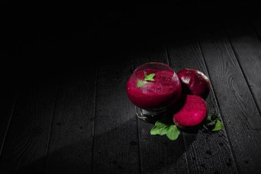 Pancar ile Close-Up yanında sağlıklı bir içecek bir siyah ahşap masa arka plan üzerinde bırakır..