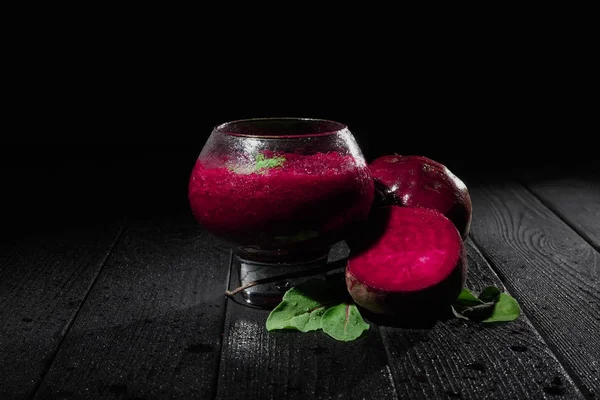 Serinletici ile geniş bir cam siyah bir arka plan üzerinde sebze güler yüzlü harmanlanmış. Şeker beetroots kesmek, pancar sağlıklı süt yoğurt yanındaki siyah ahşap bir masa üzerinde bırakır. Kopya alanı.