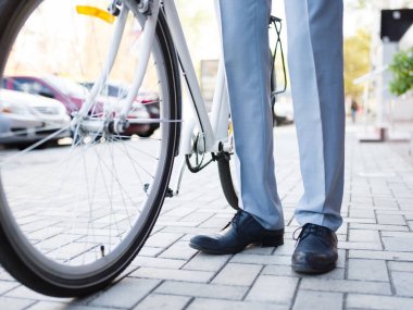 Bir bisikleti ile yakın çekim adam. Kentsel arka plan üzerinde bisiklet lider elbiseli adam. Çevre kavramı kaydetme.