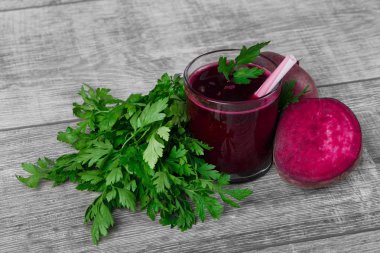 Doymuş kırmızı pancar bir ışık ahşap Resepsiyon arka plan üzerinde kokteyl süslü bir bardak. Bir dilimlenmiş yarım pancar ve taze salata. Bir saman ile ekşi veggie içki. Tarım ve sağlık kavramı.