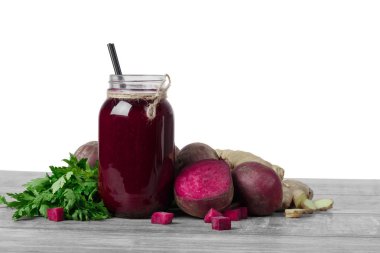 Yakın çekim canlı mor kırmızı pancar, pancar güler yüzlü, pancar küp, aromatik zencefil bir ışık beyaz arka plan üzerinde izole ahşap bir masa üzerinde bir cam mason kavanoz.