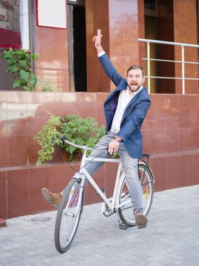 İşadamı caddeden aşağı beyaz bisiklet sürme