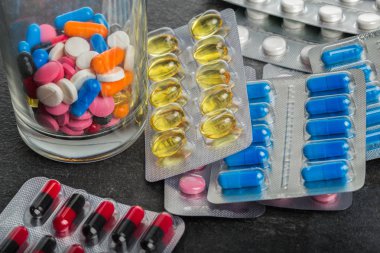 Bir gri tablosudur arka plan üzerinde renkli tablet ile paketleri. Reçeteli ilaç uyuşturucu. Sağlık kavramı.