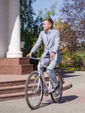 Bisikletle güzel elbiseli bir adam sokakta rides