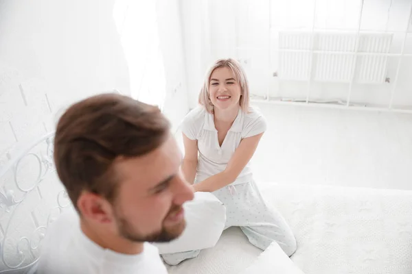 Beautiful young couple together in bed. Happy couple in bedroom on a white background.