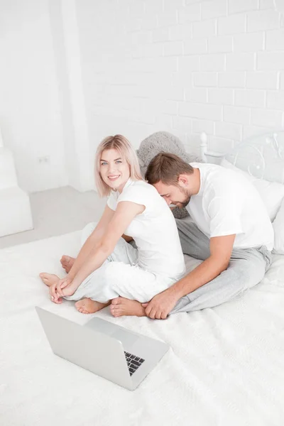 性感的年轻夫妇一起躺在床上。幸福的夫妇，在白色背景上孤立的卧室里. — 图库照片