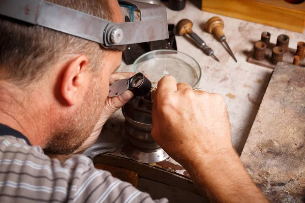 Primer plano de un joyero en el trabajo sobre un fondo de taller. Equipo de manualidades. Concepto de joyería hecha a mano . — Foto de Stock