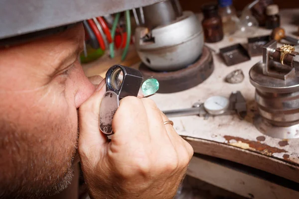 Un joyero de cerca trabajando. Artesano haciendo joyas en un fondo de taller. Concepto de fabricación de accesorios . — Foto de Stock