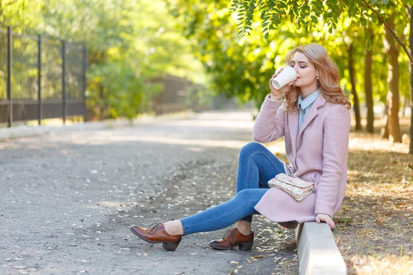 Güzel sarışın Kaldırıma park kahve ile oturuyor.