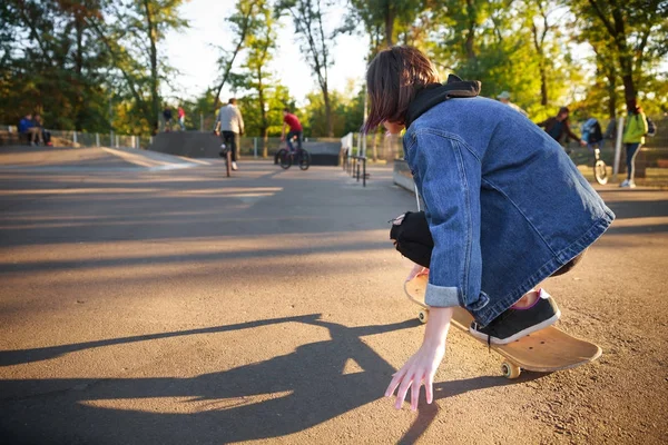 Menina sentada no skate. Skateboarding. Ao ar livre, estilo de vida . — Fotografia de Stock