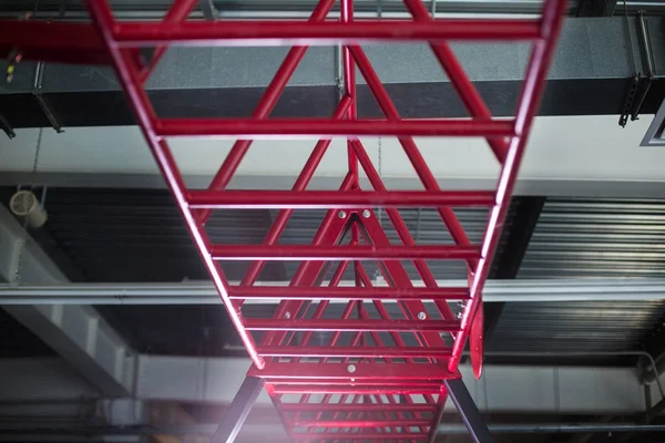 Kızıl silindirik metal, katı yukarıda tutulur çelik barlar ve açık bir gümüş renkli katta, ekipman spor yarışmaları için paralel yakın çekim. Spor egzersizleri için merdiven.