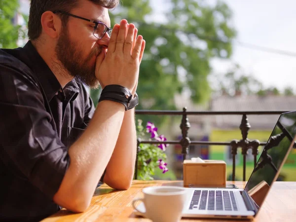 Bir genç sakallı adam onun laptop kullanarak bir kafede oturuyor.