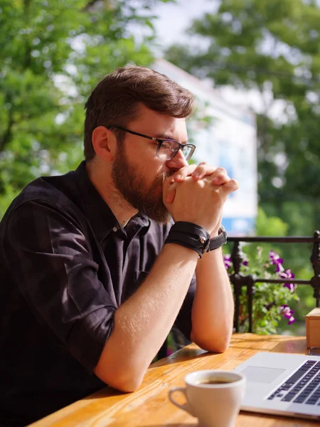 Bir genç sakallı adam onun laptop kullanarak bir kafede oturuyor.