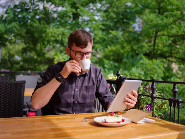 Bir genç sakallı adam onun laptop kullanarak bir kafede oturuyor.