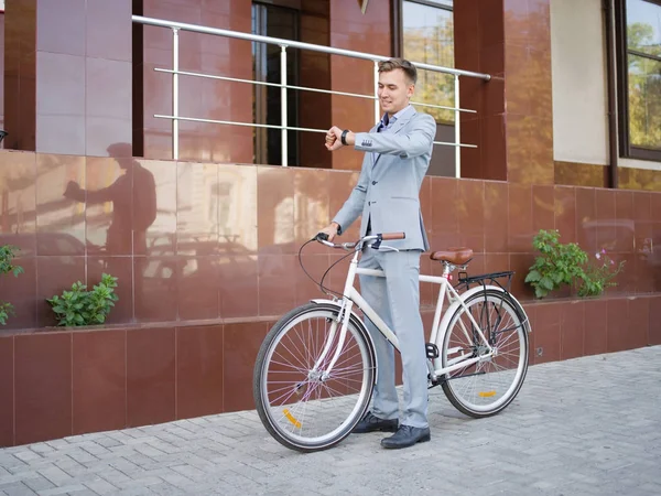 Yakışıklı işadamı kentsel arka plan üzerinde bir bisiklet sürme. Sağlıklı yaşam konsepti. Kopya alanı.