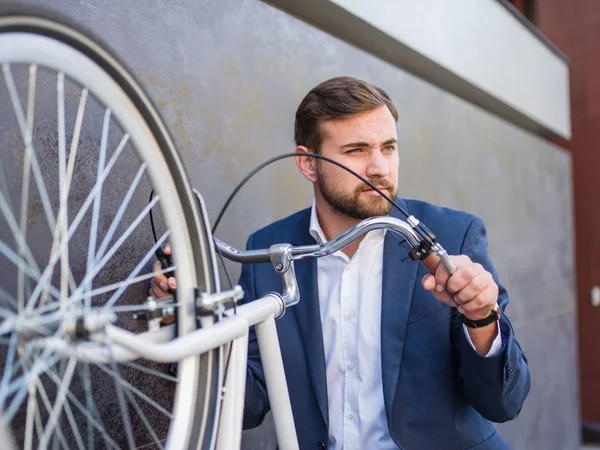 El hombre de negocios levantó su bicicleta blanca y se puso de pie — Foto de Stock