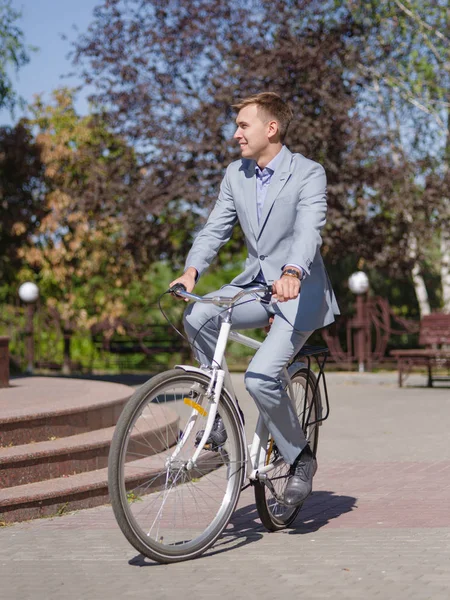 Bisikletle güzel elbiseli bir adam sokakta rides