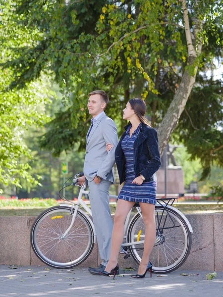 Un tipo con una bicicleta y una chica está caminando por la calle — Foto de Stock