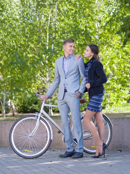 Парень на велосипеде и девушка идут по улице. — стоковое фото