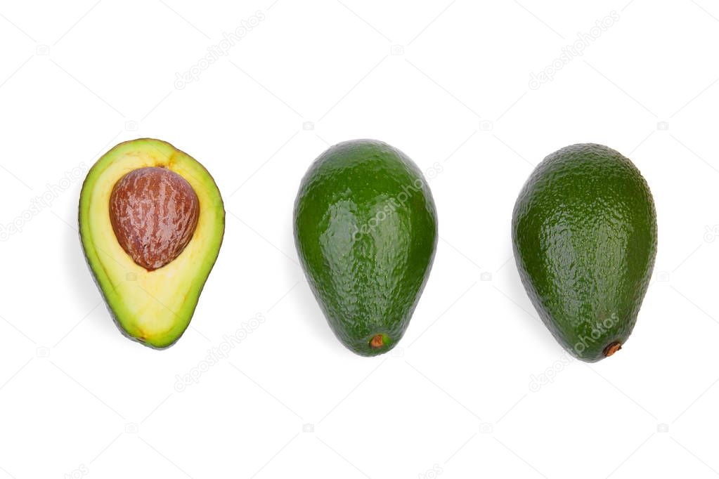 A top view of two whole green avocados and one cut in half, isolated on a white background. An organic, fresh, and ripe avocado with a large stone. Three healthful and colorful fruits in a row.